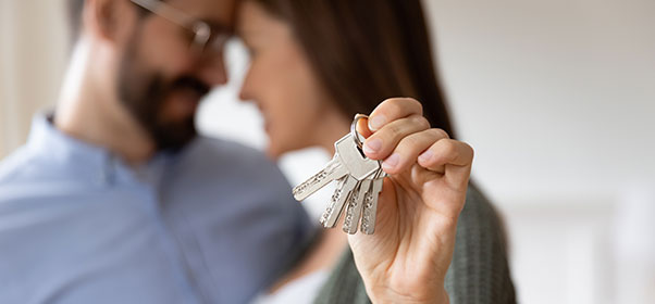 Couple embracing, holding keys to home