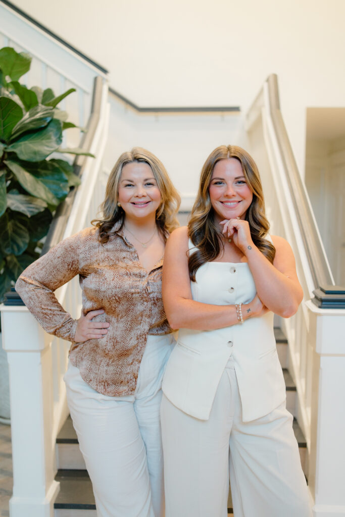 Tori and Kristen standing in front of stairs